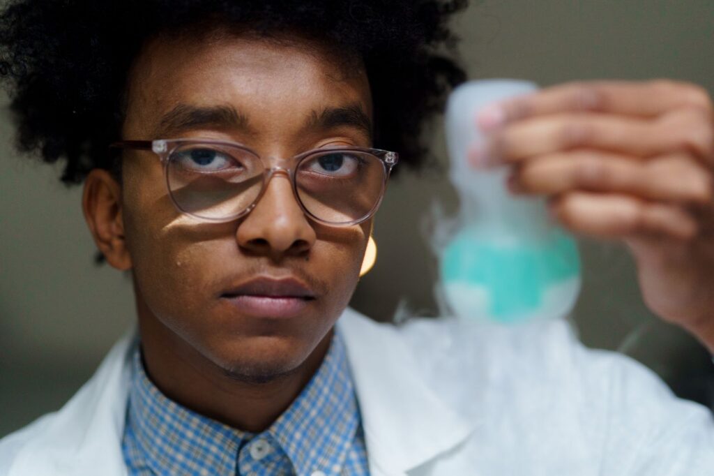 Student examining a chemistry flask – Unique Eagles Chemistry Class